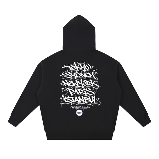 A black pullover hoodie shown from the back, featuring a large white graphic print with stylized city names including Tokyo, London, New York, Paris, and Istanbul, along with a small circular logo near the bottom.